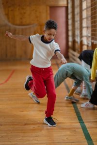 Young boy energetically moving in an indoor gym, capturing the spirit of playfulness.