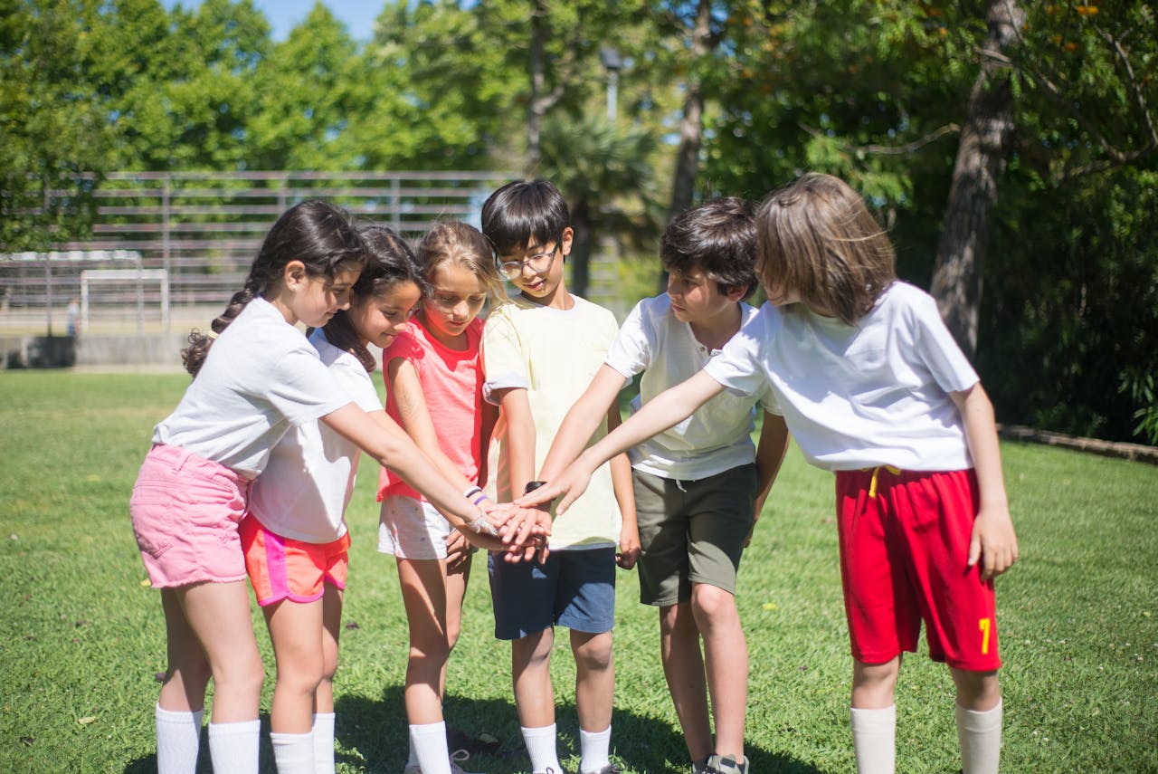 Accueil Group of kids enjoying outdoor playtime, displaying teamwork and happiness in a sunny park.